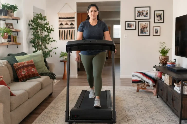 Hispanic woman walking on the best treadmill under $500 in a cozy American living room