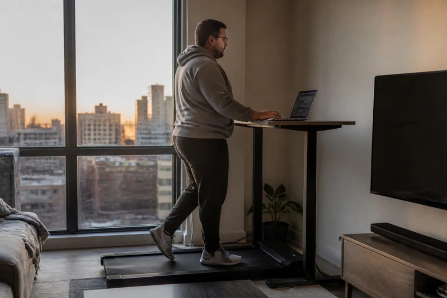 Plus-size man walking on a walking pad with a handle at home