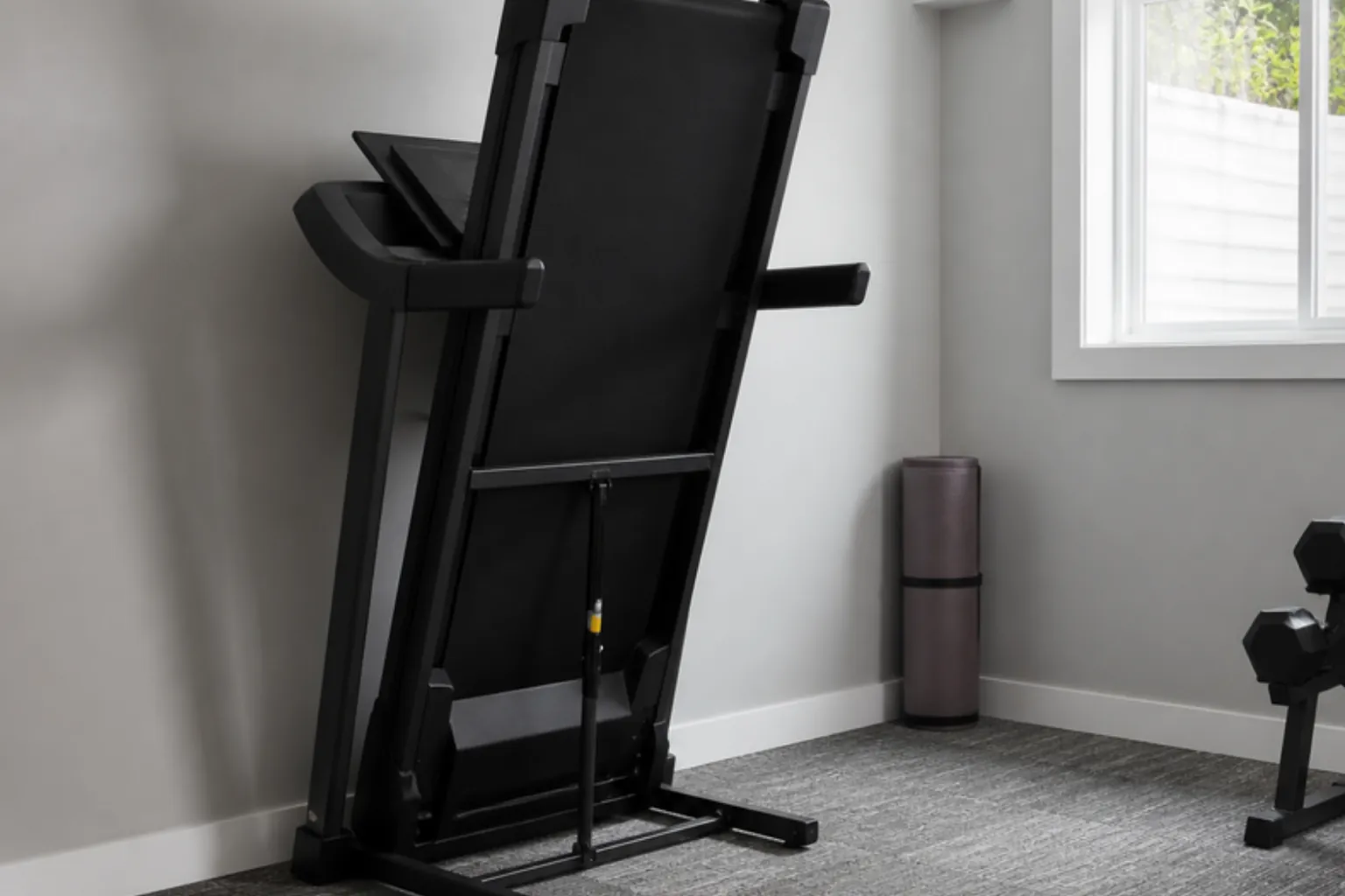 Horizon 7.4 AT folded upright in a home gym